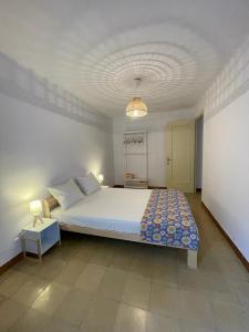 a bedroom with a large white bed and a lamp at Piso en la costa brava y al inicio del Pirineo in Portbou