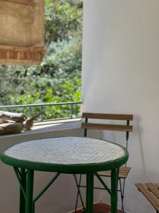 a green table and a bench in front of a window at Piso en la costa brava y al inicio del Pirineo in Portbou