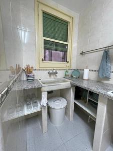 a white bathroom with a sink and a toilet at Piso en la costa brava y al inicio del Pirineo in Portbou