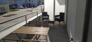 a balcony with chairs and a bench on a building at Bel appt neuf - vue mer - terrasse - parking privé in Dunkerque