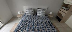 a bedroom with a bed with blue and white pillows at Bel appt neuf - vue mer - terrasse - parking privé in Dunkerque