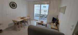 sala de estar con sofá, mesa y ventana en Bel appt neuf - vue mer - terrasse - parking privé en Dunkerque