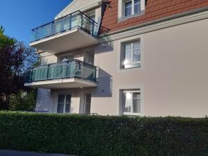 a white building with a balcony on the side of it at Les Myrtilles in Thann