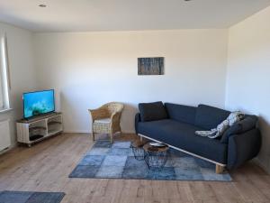 a living room with a couch and a tv at Haus Eisfenn in Blankenheim