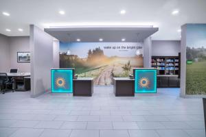 a store lobby with three signs on the wall at La Quinta by Wyndham West Memphis in West Memphis