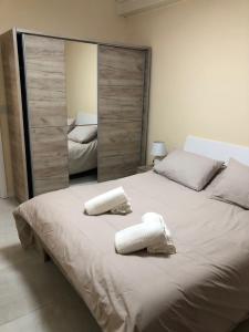 una camera da letto con un grande letto con due asciugamani di The Sea Across the Road - Flat 4 a San Pawl il-Baħar