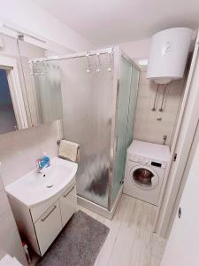 La salle de bains est pourvue d'un lavabo et d'un lave-linge. dans l'établissement Apartment Glavarić, à Omiš