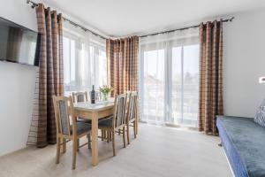 uma sala de jantar com mesa e cadeiras em Apartamenty PIAMOLA Omega em Kąty Rybackie