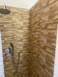 y baño con ducha y pared de madera. en Villa D'Angelo, en Ascea
