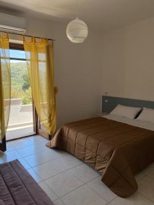 1 dormitorio con cama y ventana grande en Villa D'Angelo, en Ascea