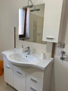 y baño con lavabo blanco y espejo. en Villa D'Angelo, en Ascea