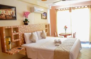 Un dormitorio con una cama grande con zapatos. en Hotel Bucaneros Isla Mujeres, en Isla Mujeres