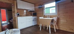 eine Küche mit weißen Schränken sowie einem Tisch und Stühlen in der Unterkunft Traum Unterkunft an der Jade in Wilhelmshaven