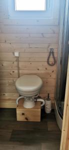 a toilet in a wooden bathroom with a window at Hausboot Wilhelmshaven - Traum Unterkunft an der Jade in Wilhelmshaven