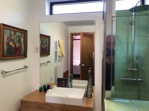 a bathroom with a sink and a shower and a mirror at Casa do Cruzeiro do Outeiro -comfort and tradition in Ponte de Lima +12 photos