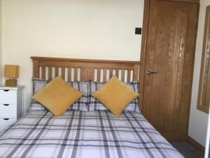 Una cama con dos almohadas amarillas encima. en 88 southshore holiday village, en Bridlington