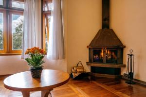 a room with a table and a fireplace at Pousada Amanita Monte Verde in Monte Verde