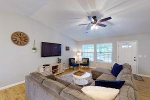 uma sala de estar com um sofá e uma TV em Pine Place em Oakhurst