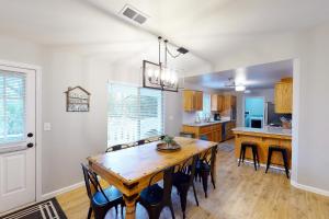 a dining room and kitchen with a wooden table and chairs at Pine Place in Oakhurst