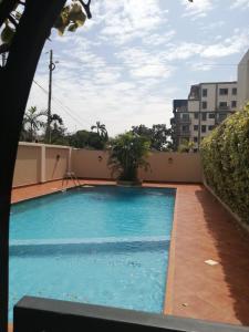 - une grande piscine bleue sur le côté d'un bâtiment dans l'établissement Tricia' s Place- One family at a time, à Accra