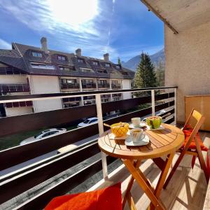 a table and chairs on a balcony with a building at Studio Mila in Kranjska Gora