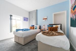 Duas camas num quarto com paredes azuis em Adom Home Away From Home 4 Beds- 5 Mins to Hull Stadium em Hull