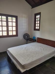 A bed or beds in a room at Camburi Chalés