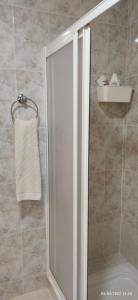 een douche met een glazen deur in de badkamer bij La casa de la playa in Santa Pola