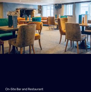 ein Restaurant mit Stühlen, Tischen und einem Kamin in der Unterkunft new Perran holiday resort in Newquay