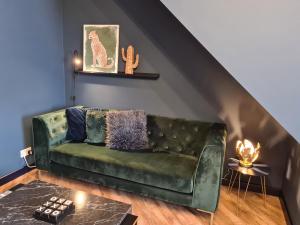 a green leather couch in a living room at Stunning 2 bed house near coastal path/lake/beach in Llanelli