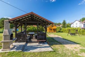 凯蒂赖贝西Domki Piamola Kąty Rybackie的公园内带野餐桌的木制凉亭