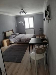 een slaapkamer met een bed, een tafel en een bureau bij Lamara apartament in Tbilisi City
