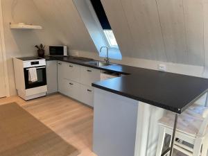 a kitchen with a black counter top and a stove at Högklint by the Sea Apartment in Visby