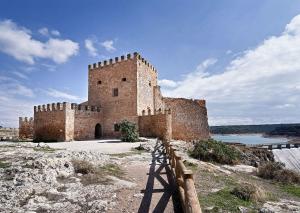 a large brick building sitting on top of a hill at AniCa I, en el corazón de la Mancha in Argamasilla de Alba