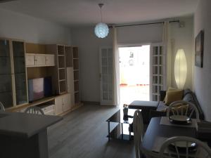een woonkamer met een bank en een tv bij Apartamento Los Cristianos Tres minutos Playa las vistas in Arona