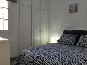 Un dormitorio con una cama en blanco y negro y una ventana en Apartamento Los Cristianos Tres minutos Playa las vistas en Arona