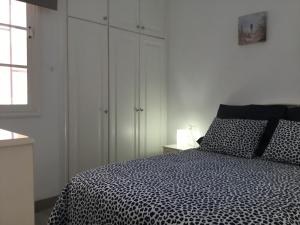 a bedroom with a black and white bed and a window at Apartamento Los Cristianos Tres minutos Playa las vistas in Arona