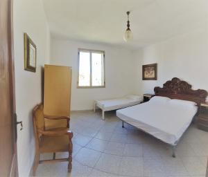 1 dormitorio con 1 cama y 1 silla en Cosy home with private parking near by sea en Siniscola