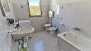 錫尼斯科拉的住宿－Cosy home with private parking near by sea，浴室配有盥洗盆、卫生间和浴缸。