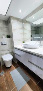 uma casa de banho com um lavatório branco e um WC. em Tiberias em Tiberias