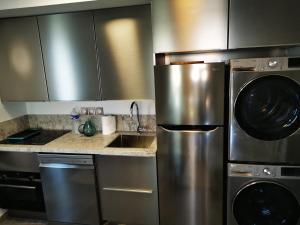 a kitchen with stainless steel appliances and a sink at appartement carqueiranne le port in Carqueiranne +9 photos