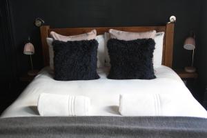 a bed with white sheets and black pillows at Salt Life Studio in Brighton & Hove