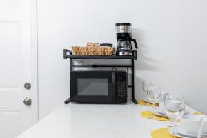 a microwave on a counter with two glasses of wine at Beautiful Casita with King Bed and private patio Close to Calle 8, MIA Airport, Coral Gables in Miami