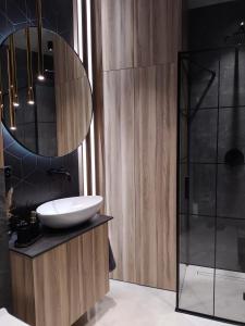 a bathroom with a sink and a mirror at Luxury Apartament Wyszyńskiego z Klimatyzacja in Radom