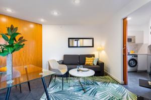 a living room with a couch and a table at Lodging Apartments City Center-Eixample in Barcelona
