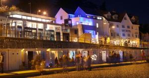 a group of people standing in front of a building at night at Largigi offering two amazing panoramic sea front apartments in Lyme Regis