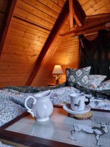 une chambre avec un canapé et deux tasses sur une table dans l'établissement Dzikie południe, à Sanok