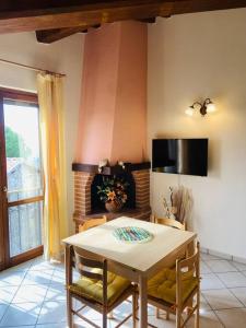une salle à manger avec une table, des chaises et une cheminée dans l'établissement A casa di Claudia, à Saturnia