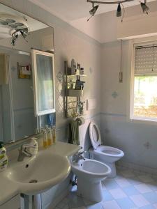 a bathroom with a sink and a toilet and a mirror at Villa Maurizio in Rio Marina