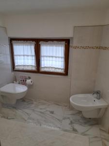 La salle de bains est pourvue d'un lavabo et de toilettes. dans l'établissement B&B Camera & Caffe, à Tempio Pausania